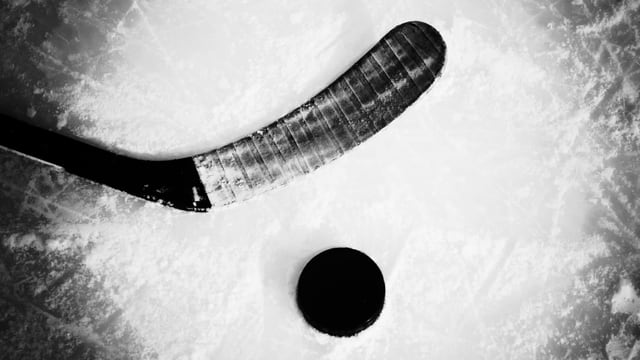 Eiskhockeyschläger auf Eis, daneben Puck. Eiskhockeyschläger auf Eis, daneben Puck.