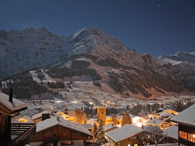 Adelboden und der Wildstrubel sind in bläuliches Licht getaucht, nur die künstlichen Lichtquellen bei den Häusern sind in warmem Gelb.