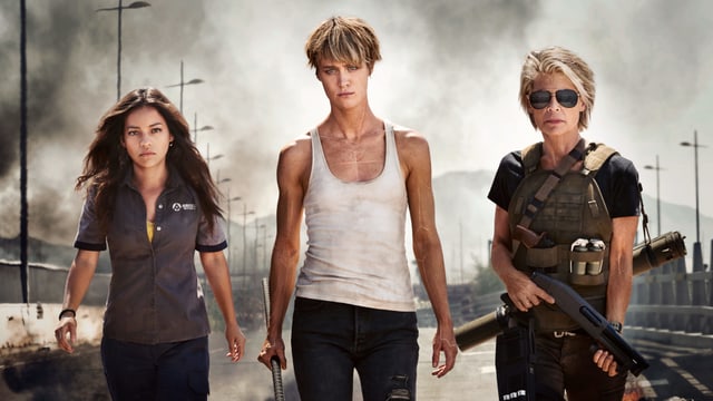 Eine braunhaarige und zwei blonde Frauen blicken in die Kamera. Die älteste hält eine Waffe. Eine braunhaarige und zwei blonde Frauen blicken in die Kamera. Die älteste hält eine Waffe.