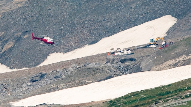 Die Flugzeugabsturzstelle, ein Helikopter und ein Bagger sind bei den Bergungsarbeiten beteiligt Die Flugzeugabsturzstelle, ein Helikopter und ein Bagger sind bei den Bergungsarbeiten beteiligt