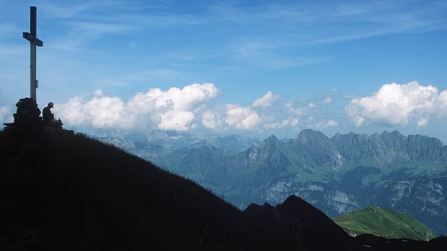 Ein Berg im Schatten. An der Spitze steht ein grosses Kreuz. Ein Berg im Schatten. An der Spitze steht ein grosses Kreuz.