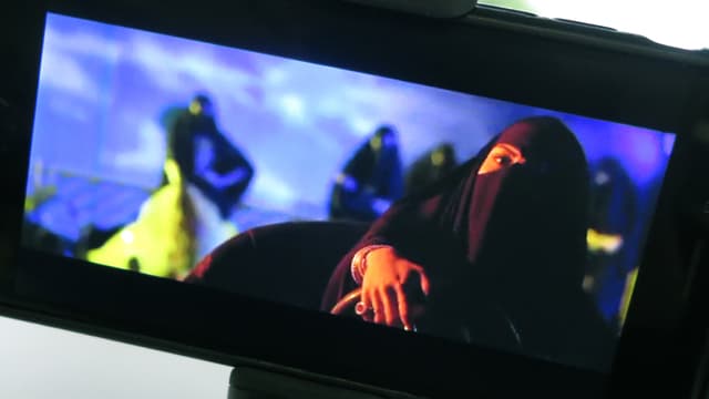 Frau im Niqab im Autoscooter. Frau im Niqab im Autoscooter.