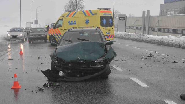 Ein Unfallauto mit komplett eingedrückter Frontpartie, dahinter die Ambulanz. Ein Unfallauto mit komplett eingedrückter Frontpartie, dahinter die Ambulanz.