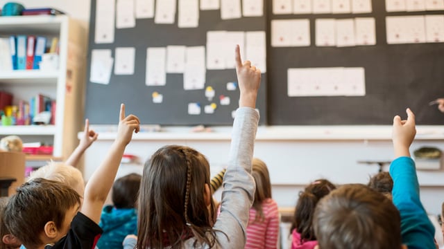 Primarschüler strecken den Finger hoch Primarschüler strecken den Finger hoch