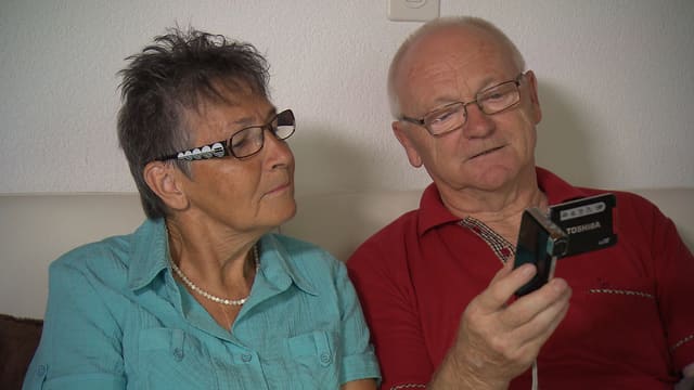 Ehepaar betrachtet eine Kamera Ehepaar betrachtet eine Kamera