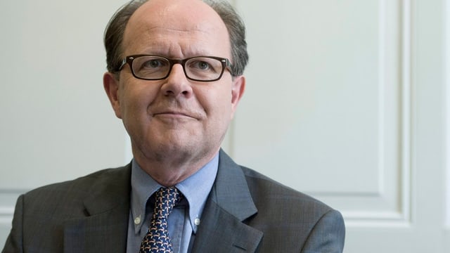Frontalaufnahme von Vez, er trägt eine Brille, Anzug und Krawatte. Frontalaufnahme von Vez, er trägt eine Brille, Anzug und Krawatte.