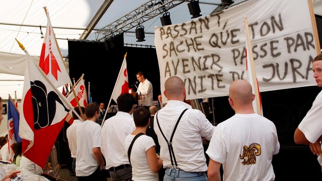 Mehrere Personen der Autonomiebewegung Mouvement autonomiste jurassien werben mit Plakaten fürn ihre Anliegen. Mehrere Personen der Autonomiebewegung Mouvement autonomiste jurassien werben mit Plakaten fürn ihre Anliegen.