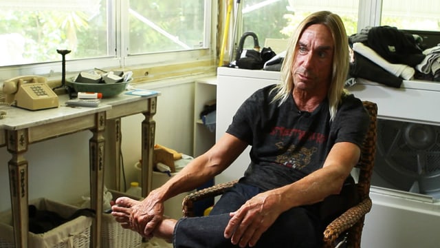 Iggy Pop sitzt in einer Wohnung auf einem Stuhl. Iggy Pop sitzt in einer Wohnung auf einem Stuhl.
