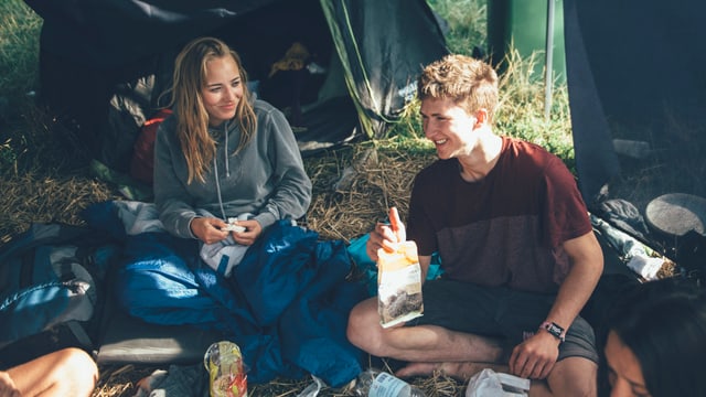 Zwei Freunde sitzen vor ihrem Zelt und sprechen über Chia-Samen Zwei Freunde sitzen vor ihrem Zelt und sprechen über Chia-Samen