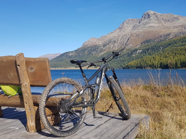 Ein Velo steht an einer Rastbank am Ufer des Sees, es ist sehr sonnig. Ein Velo steht an einer Rastbank am Ufer des Sees, es ist sehr sonnig.