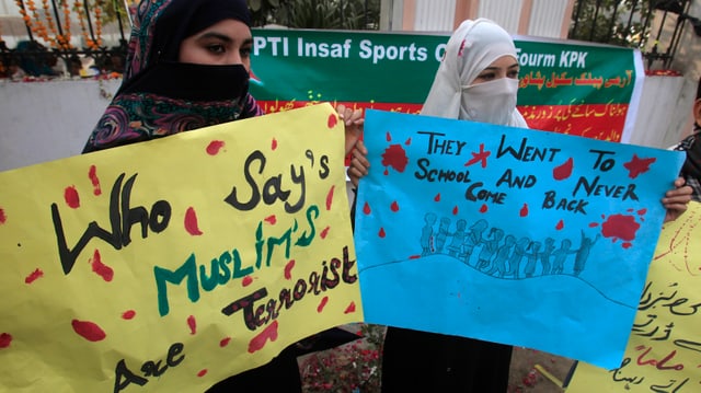 Zwei Musliminnen halten Transparente in den Händen. Zwei Musliminnen halten Transparente in den Händen.