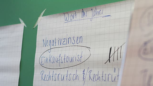 Wort Einkaufstourist steht zusammen mit anderen Wörtern auf einem Zettel Wort Einkaufstourist steht zusammen mit anderen Wörtern auf einem Zettel
