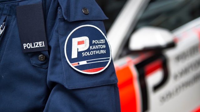 Polizist vor Streifenwagen in Solothurn Polizist vor Streifenwagen in Solothurn