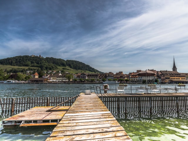 Steg zum Fluss, dahinter Altstadt. Himmel mit Cirrenwolken.