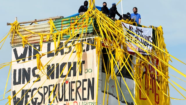 Hausbesetzer auf einem Hausdach. Hausbesetzer auf einem Hausdach.
