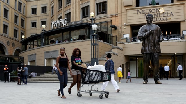 Frauen mit Einkaufswagen vor einem Shopping Center Frauen mit Einkaufswagen vor einem Shopping Center