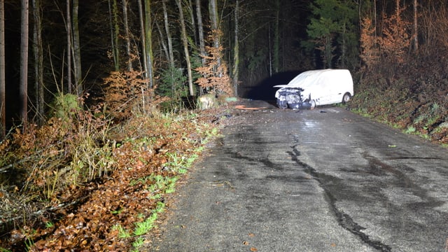 Ein Auto steht quer auf einer Waldstrasse. Die Front ist eingedrückt Ein Auto steht quer auf einer Waldstrasse. Die Front ist eingedrückt