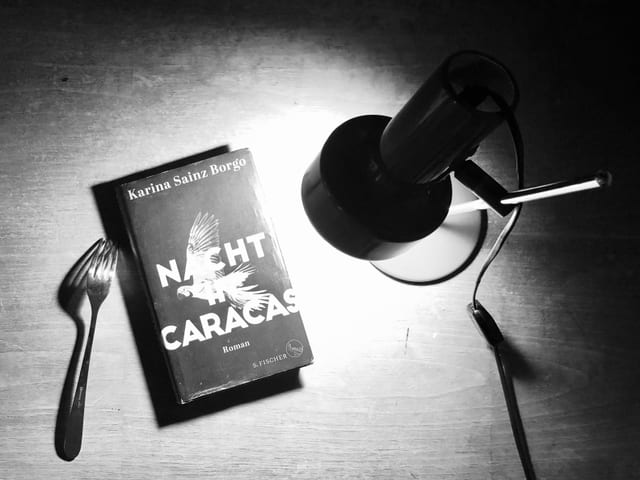 Der Roman «Nacht in Caracas» liegt im Lichtkegel einer Tischlampe Der Roman «Nacht in Caracas» liegt im Lichtkegel einer Tischlampe