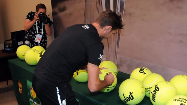 Wawrinka unterschreibt Souvenirs. Wawrinka unterschreibt Souvenirs.