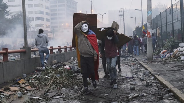 Maskierte Protestierende in den Strassen von Quito. Maskierte Protestierende in den Strassen von Quito.