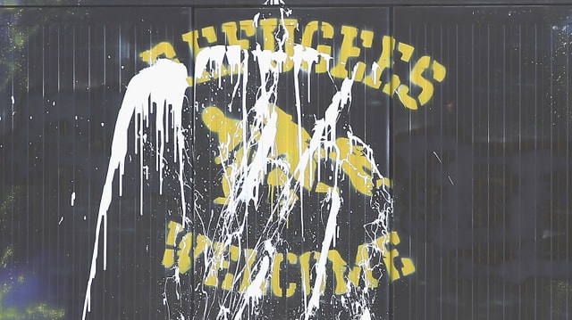 Eine Aufschrift «Refugees Welcome» an einer Hauswand wurde mit Farbe bespritzt. Eine Aufschrift «Refugees Welcome» an einer Hauswand wurde mit Farbe bespritzt.