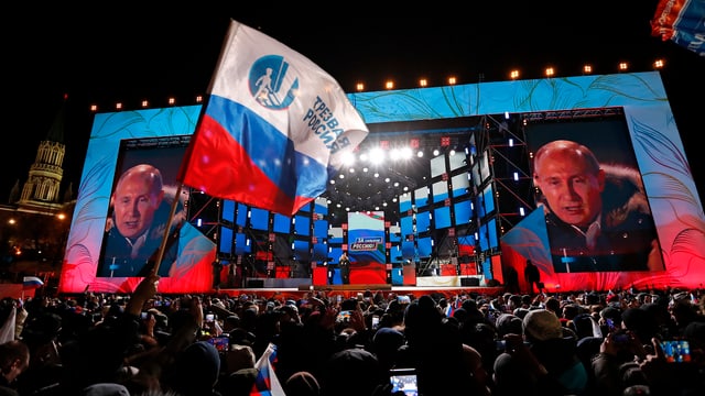 Putin spricht auf einem Platz nach seiner Wiederwahl. Er ist auf einer Grossleinwand gleich doppelt zu sehen. Putin spricht auf einem Platz nach seiner Wiederwahl. Er ist auf einer Grossleinwand gleich doppelt zu sehen.