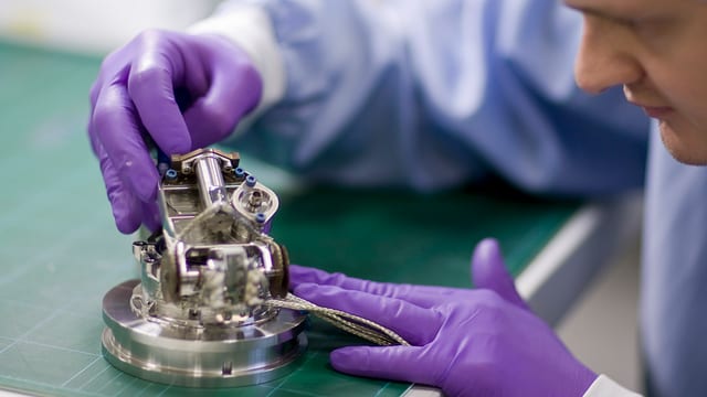 Mann schraubt an technischem Bauteil. Mann schraubt an technischem Bauteil.