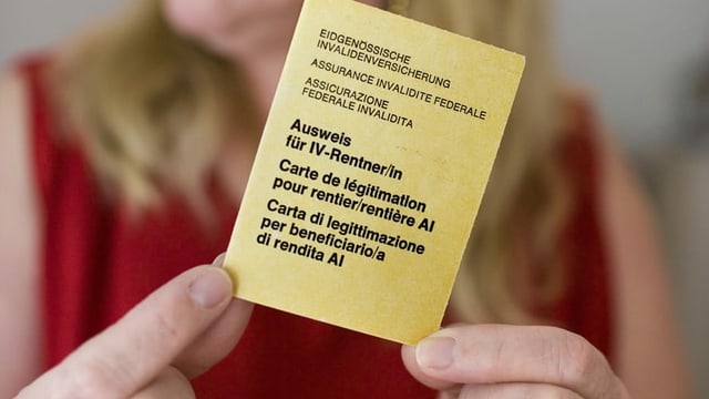 Person hält einen IV-Ausweis in den Händen. Person hält einen IV-Ausweis in den Händen.