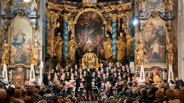 Ein Orchester spielt vor Publikum in einer prunkvollen Kirche. Ein Orchester spielt vor Publikum in einer prunkvollen Kirche.