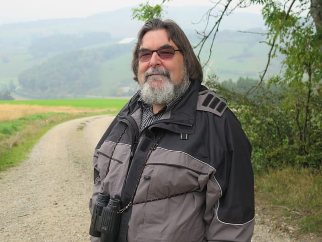 Ein Mann Brille und Bart steht vor nebligem Hintergrund Ein Mann Brille und Bart steht vor nebligem Hintergrund