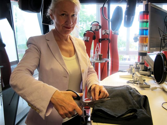 Frau setzt Schere an Hose an. Frau setzt Schere an Hose an.