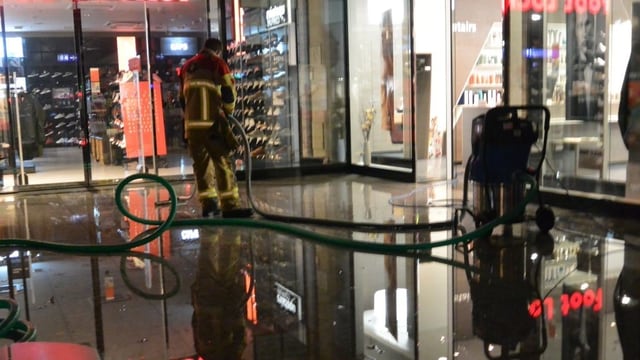 Feuerwehrmann mit Schlauch, am Boden Wasser Feuerwehrmann mit Schlauch, am Boden Wasser