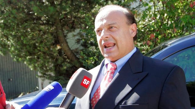 Lardelli spricht in Mikrofone. Lardelli spricht in Mikrofone.
