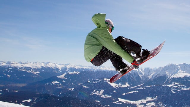 Ein Snowboarder springt durch die Lüfte.