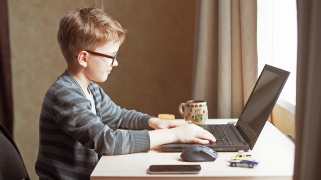 Ein Kind schreibt auf einem Computer. Ein Kind schreibt auf einem Computer.