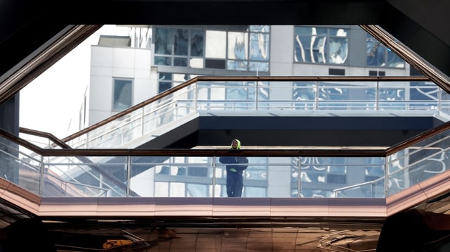 Ein Mann steht auf einer bronzefarbenen Treppe. Ein Mann steht auf einer bronzefarbenen Treppe.