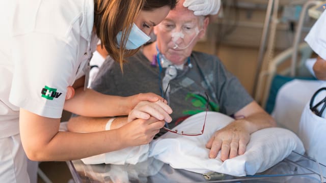 Eine Krankenschwester kümmert sich um einen Patienten. Eine Krankenschwester kümmert sich um einen Patienten.