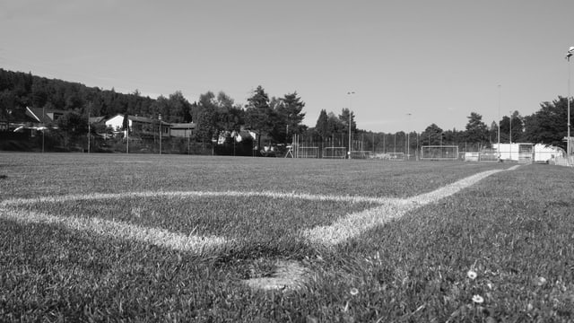 Eine Schwarz-Weiss-Aufnahme eines Fussballplatzes, fotografiert vom Boden aus mit Blick aus dem Cornerfeld heraus. Eine Schwarz-Weiss-Aufnahme eines Fussballplatzes, fotografiert vom Boden aus mit Blick aus dem Cornerfeld heraus.