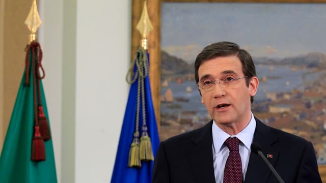 Pedro Passos Coelho spricht vor zwei Flaggen und einem Gemälde in ein Mikrofon. Pedro Passos Coelho spricht vor zwei Flaggen und einem Gemälde in ein Mikrofon.