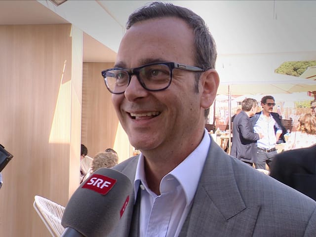 Mann mit schwarer Brille gibt ein Interview. Mann mit schwarer Brille gibt ein Interview.