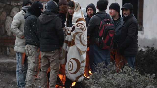 Flüchtlinge in der Türkei stehen um ein wärmendes Feuer herum. Flüchtlinge in der Türkei stehen um ein wärmendes Feuer herum.