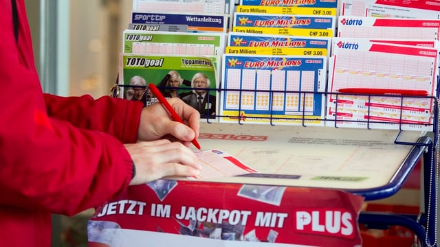 Eine Frau füllt einen Lotto-Schein aus. Eine Frau füllt einen Lotto-Schein aus.