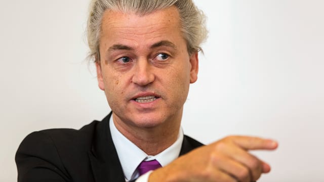 Brustbild von Wilders, der mit Zeigefinger auf die Seite deutet. Brustbild von Wilders, der mit Zeigefinger auf die Seite deutet.