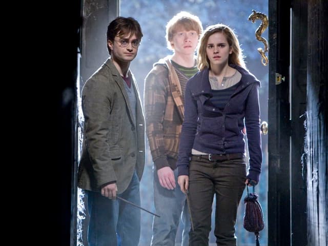 Die drei Hauptfigurebn aus Harry Potter in einem dunklen Gang.
