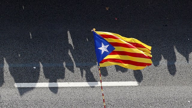 Menschenschatten hinter der Flagge Kataloniens Menschenschatten hinter der Flagge Kataloniens