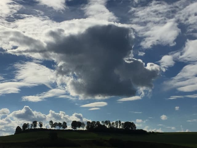 Über dem Wauwilermoos zeigen sich Föhn- und Schauerwolken, der Himmel ist teils noch blau.