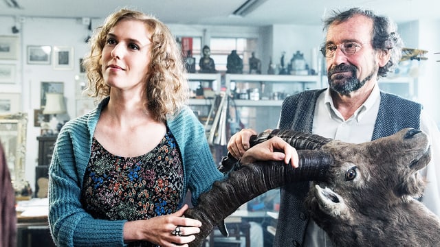 Eine Frau und ein Mann stehen bei einem Steinbockkopf Eine Frau und ein Mann stehen bei einem Steinbockkopf