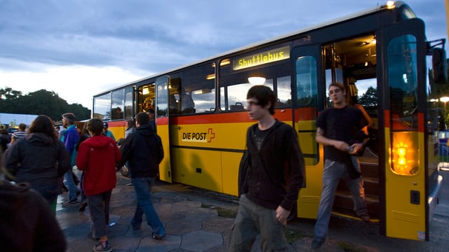 Postauto mit offenen Türen, Leute steigen aus Postauto mit offenen Türen, Leute steigen aus