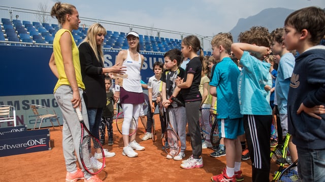 Kinder hören drei Tennisspielerinnen zu. Kinder hören drei Tennisspielerinnen zu.