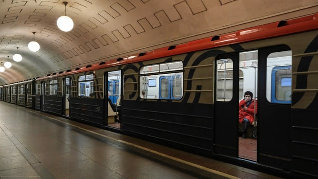 U-Bahn in einer Station, eine Person sitzzt drin, hält die Hand an den Mundschutz U-Bahn in einer Station, eine Person sitzzt drin, hält die Hand an den Mundschutz